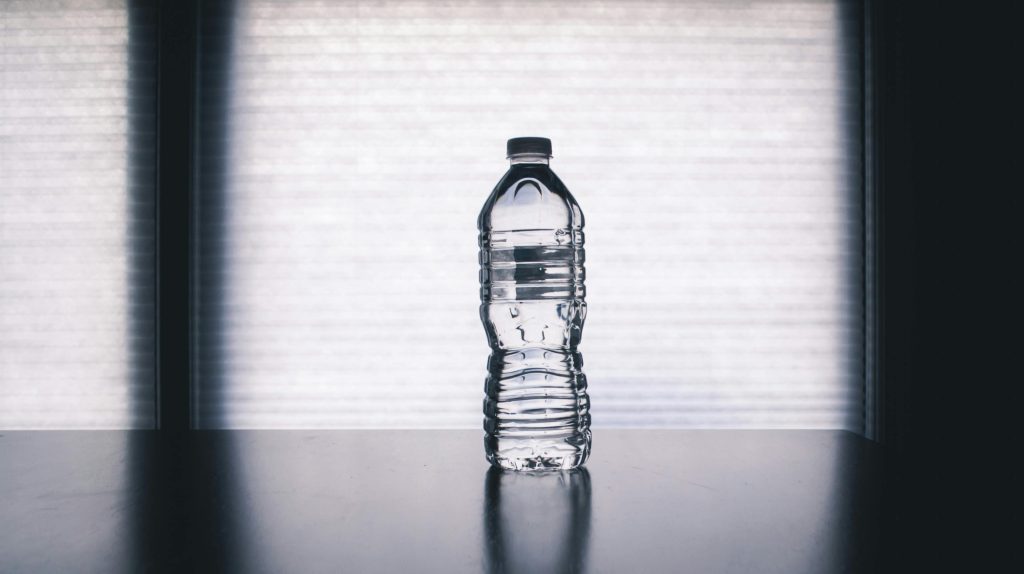 pexels-photo-1000084-1000084 Stylish photo of a clear plastic water bottle on a reflective surface with a soft shadow.